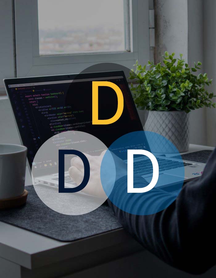 Photograph of a person using a laptop at a desk, with only their hands being visible. DDD text overlays the image relating to Developer Training