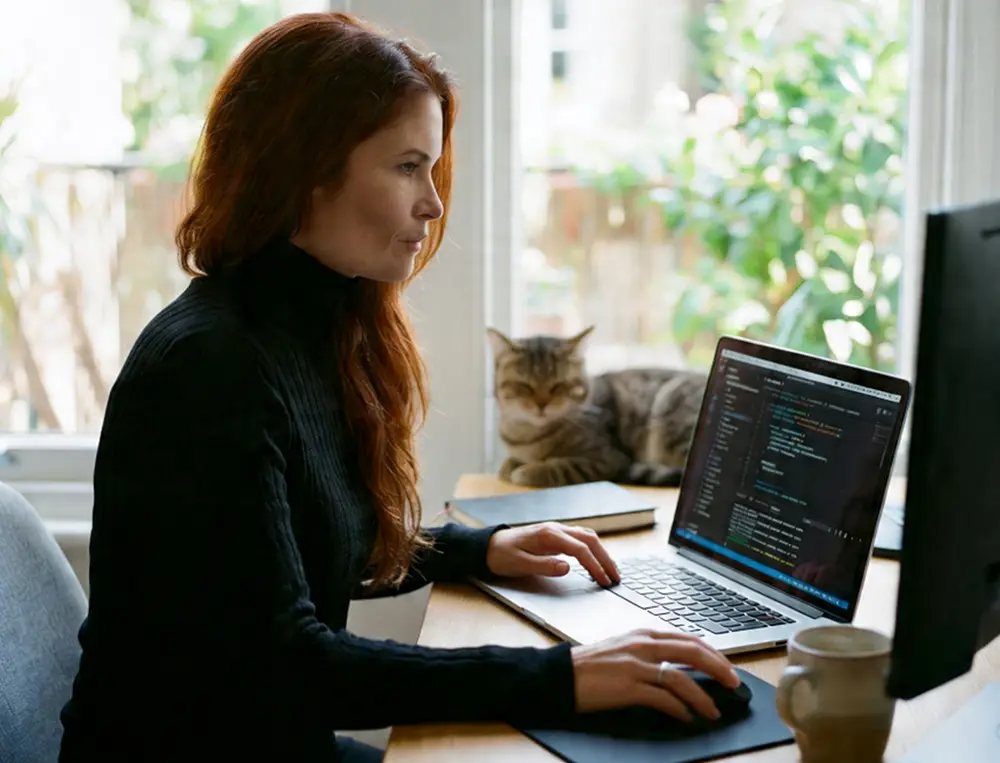 KRS female employee orking at a des with a laptop and a monitor